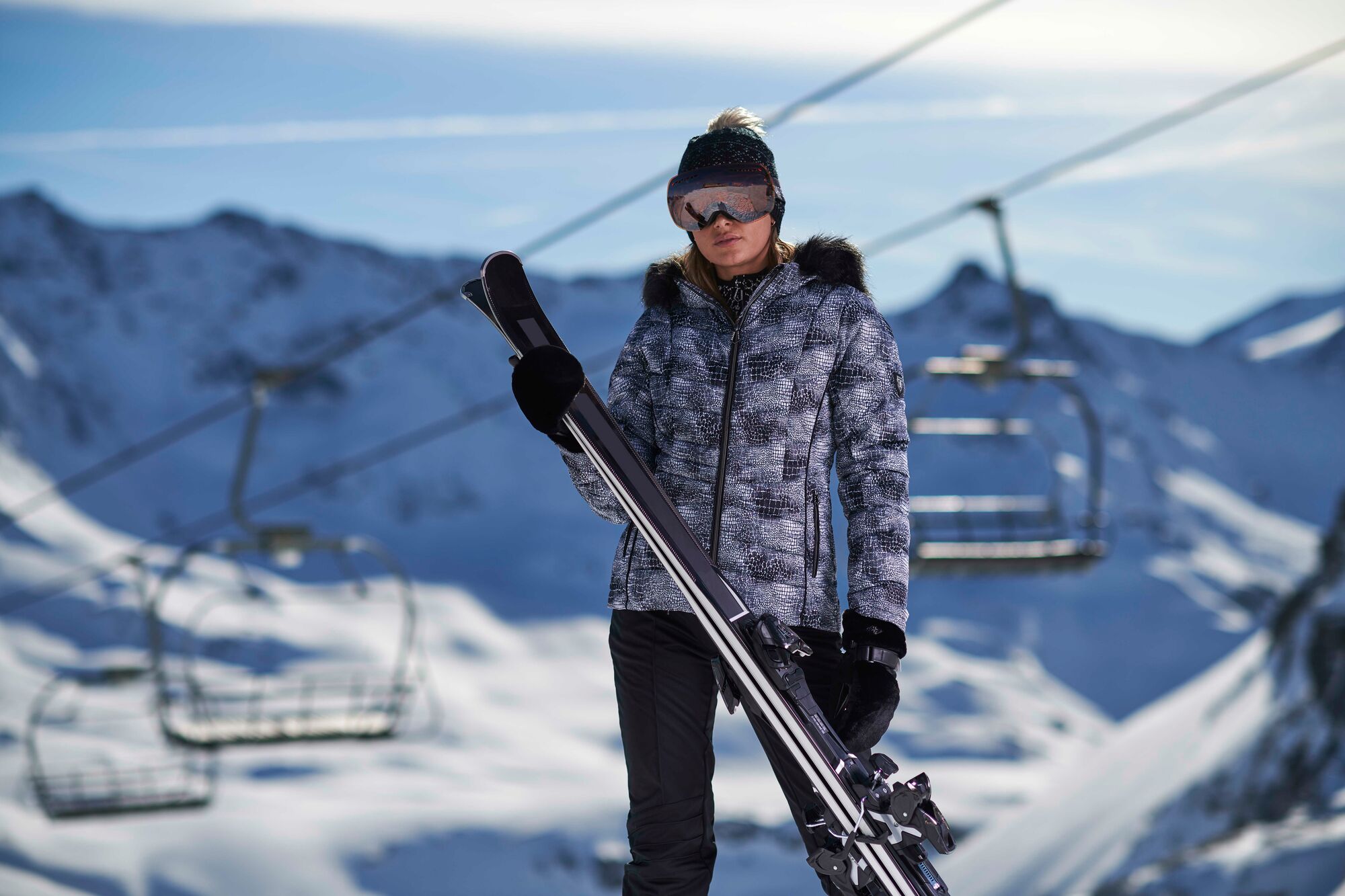 woman stood on mountain with skis