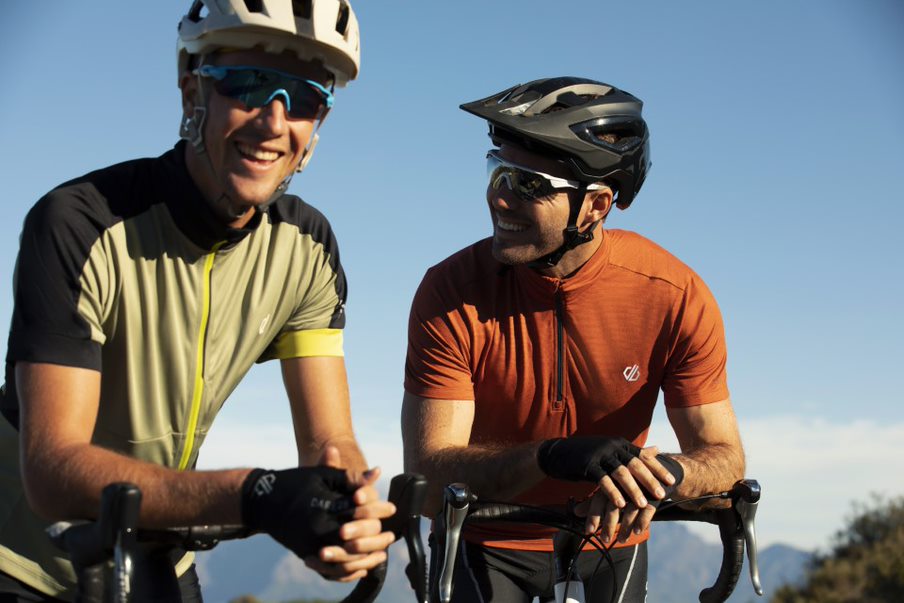 two men sat on road bikes laughing